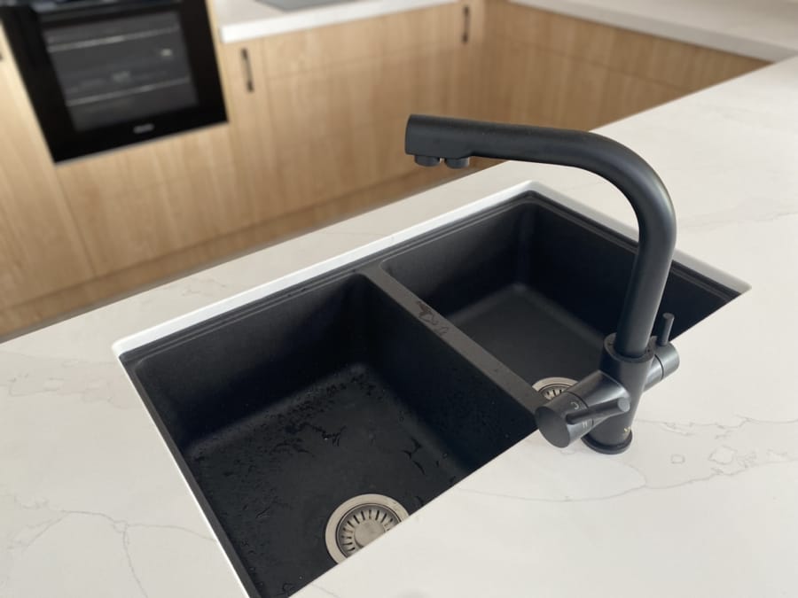 black kitchen sink with white stone top